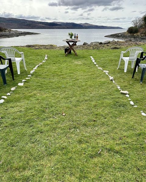Image showing plastic chairs set up for a wedding ceremony looking out on to water in the background with a small table in the centre