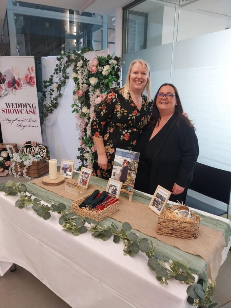 2 woman behind a table at a wedding showcase
