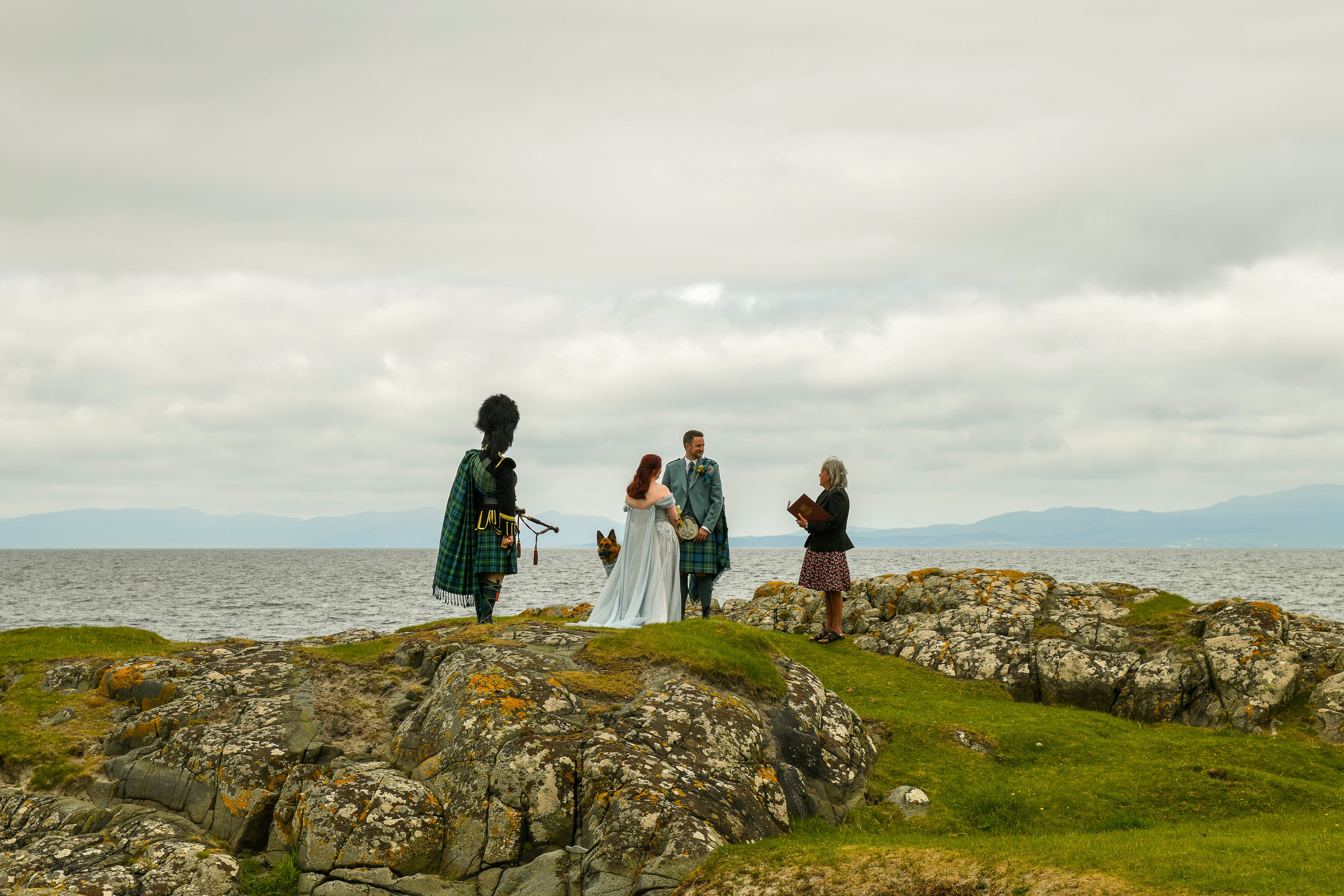 Bride Groom Registrar Piper and a dog standing on a cliff edge