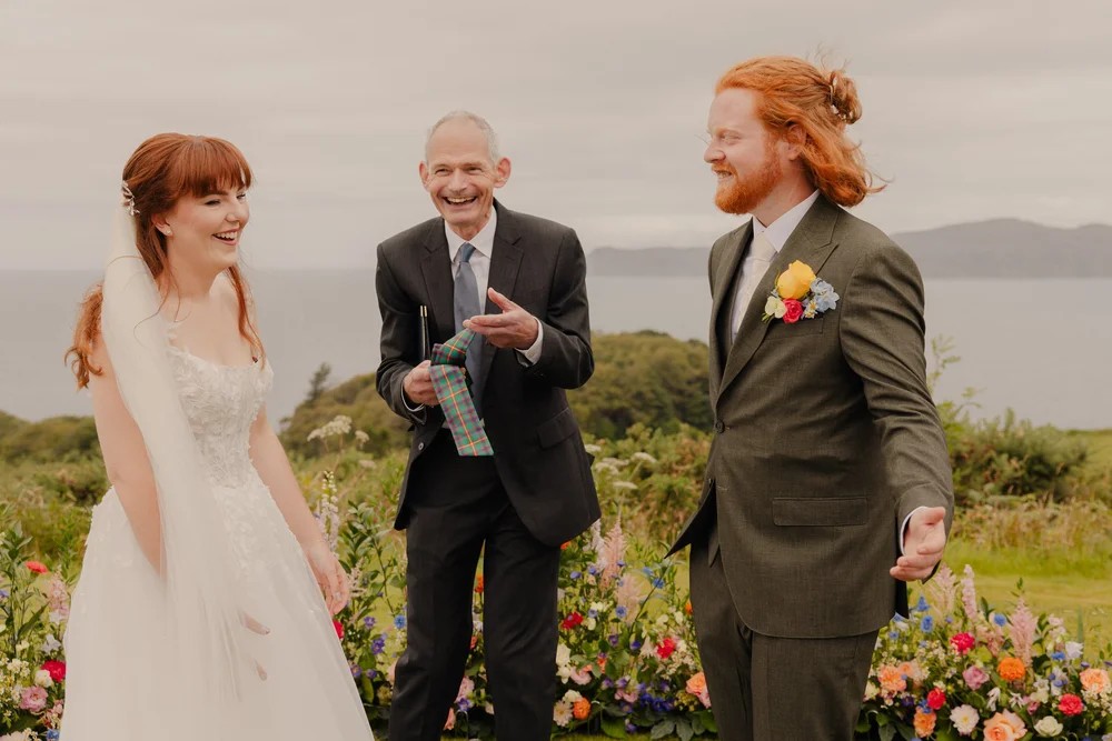 a man holding tartan, with a bride and groom