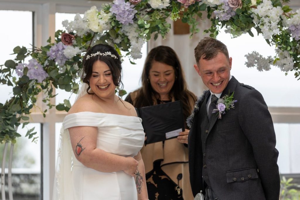 bride groom and registrar standing laughing