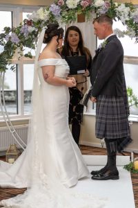 bride groom holding hands and registrar in the middle