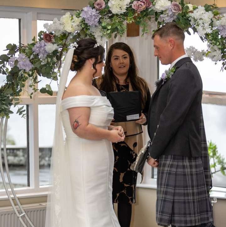bride groom holding hands and registrar in the middle