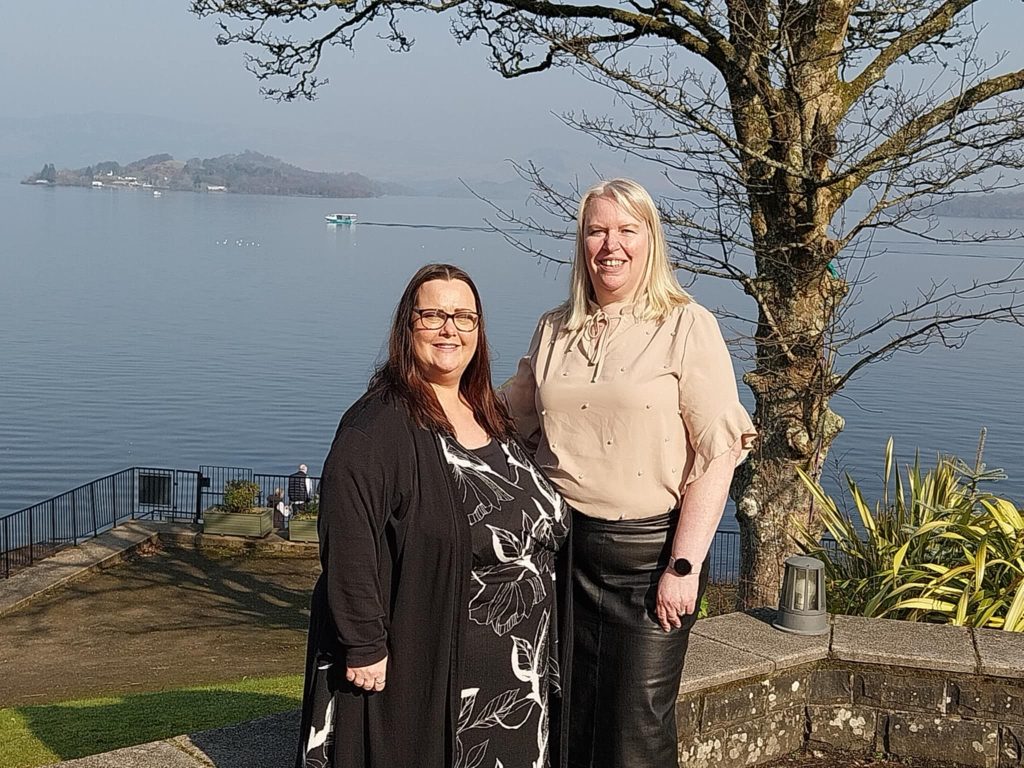 2 woman standing in front of water