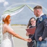 woman in white dress holding man in suit hand with a lady in the middle
