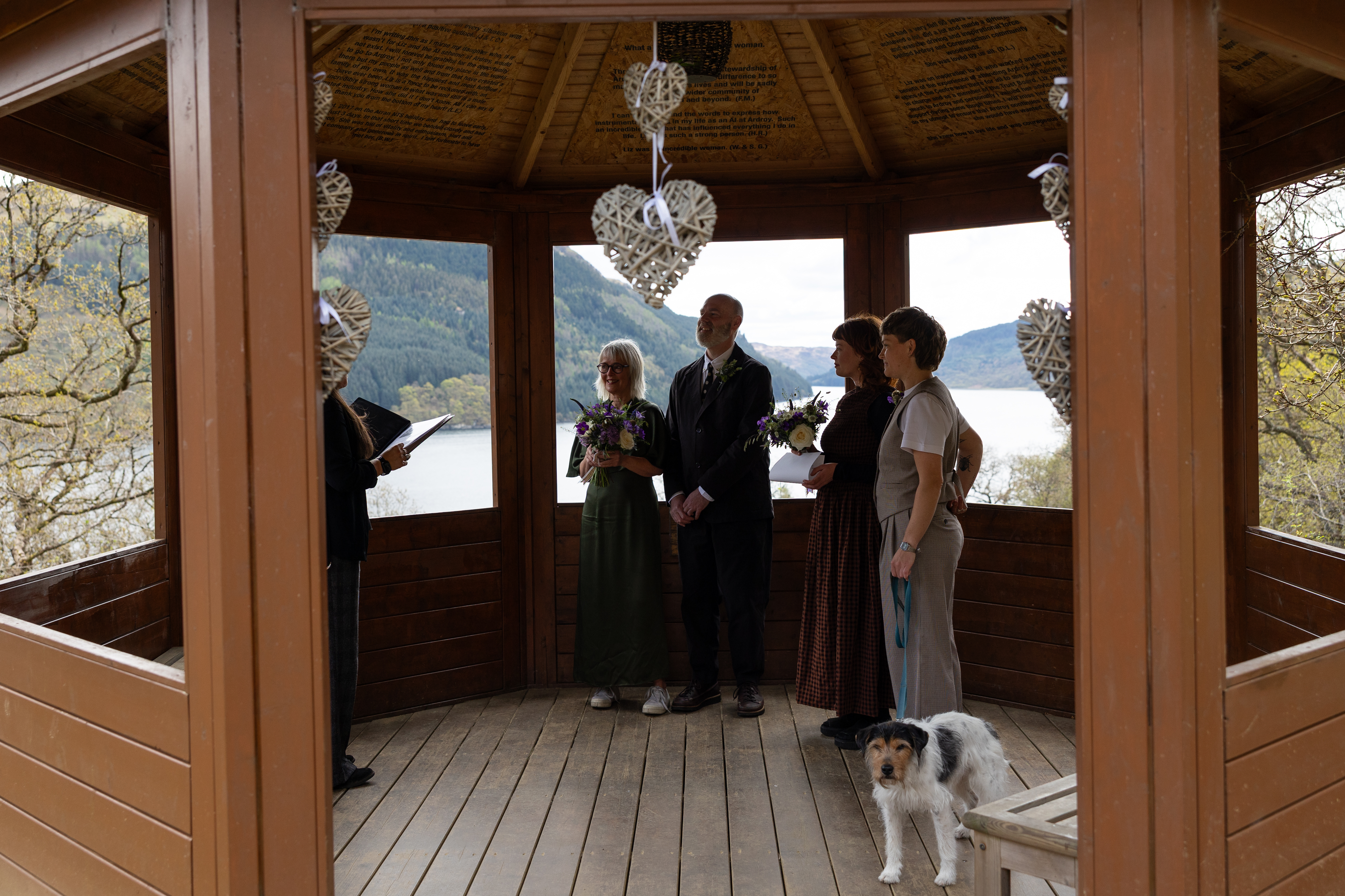a shelter with 5 people standing and a dog