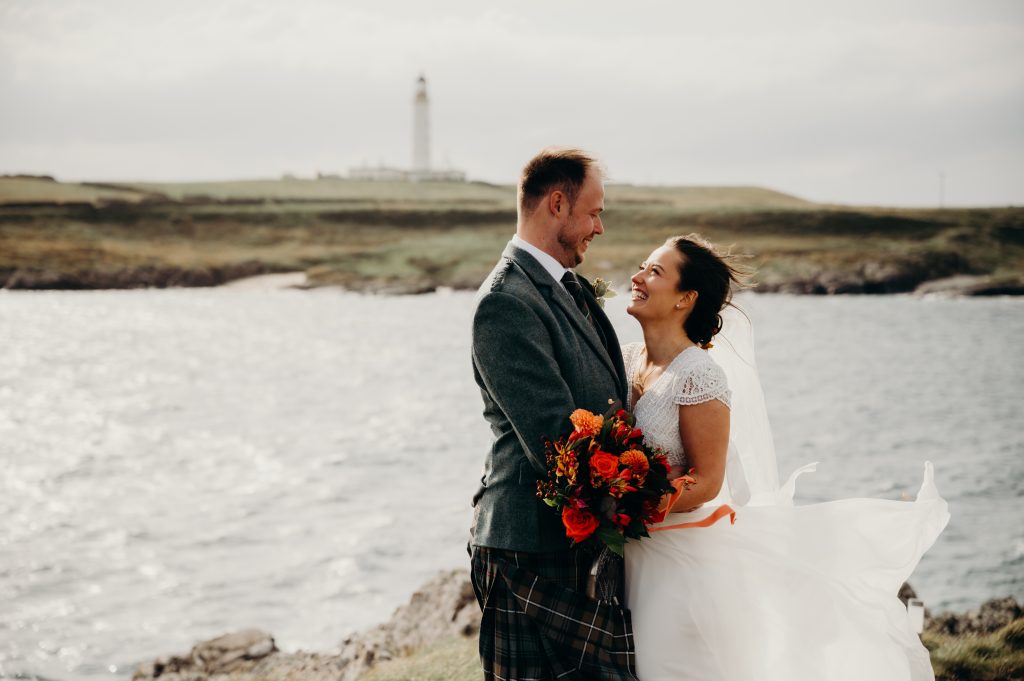 man and woman looking at each other with water in background