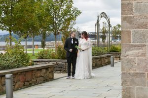 woman in white dress standing with man in black suit and white tie