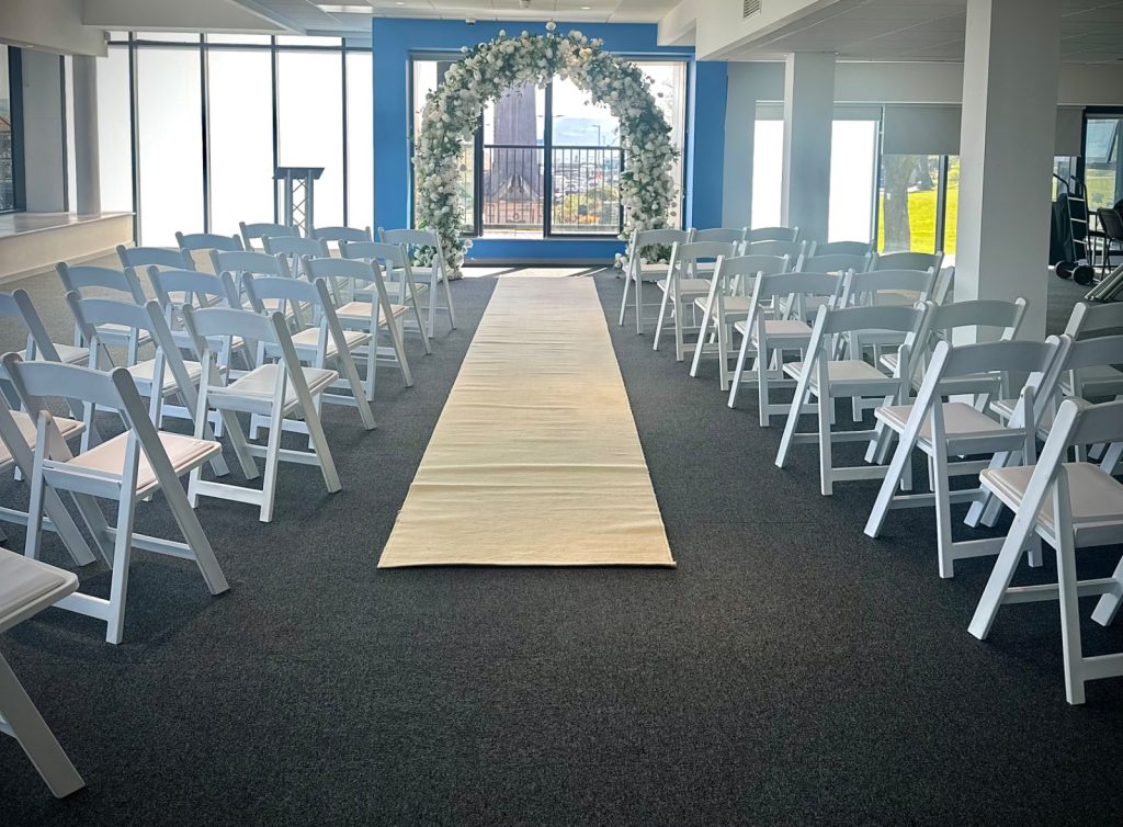 image showing a room with chairs set up for a wedding ceremony