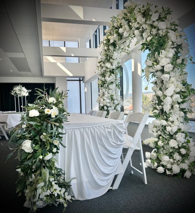 image showing a top table for a wedding surrounded by floral arrangements