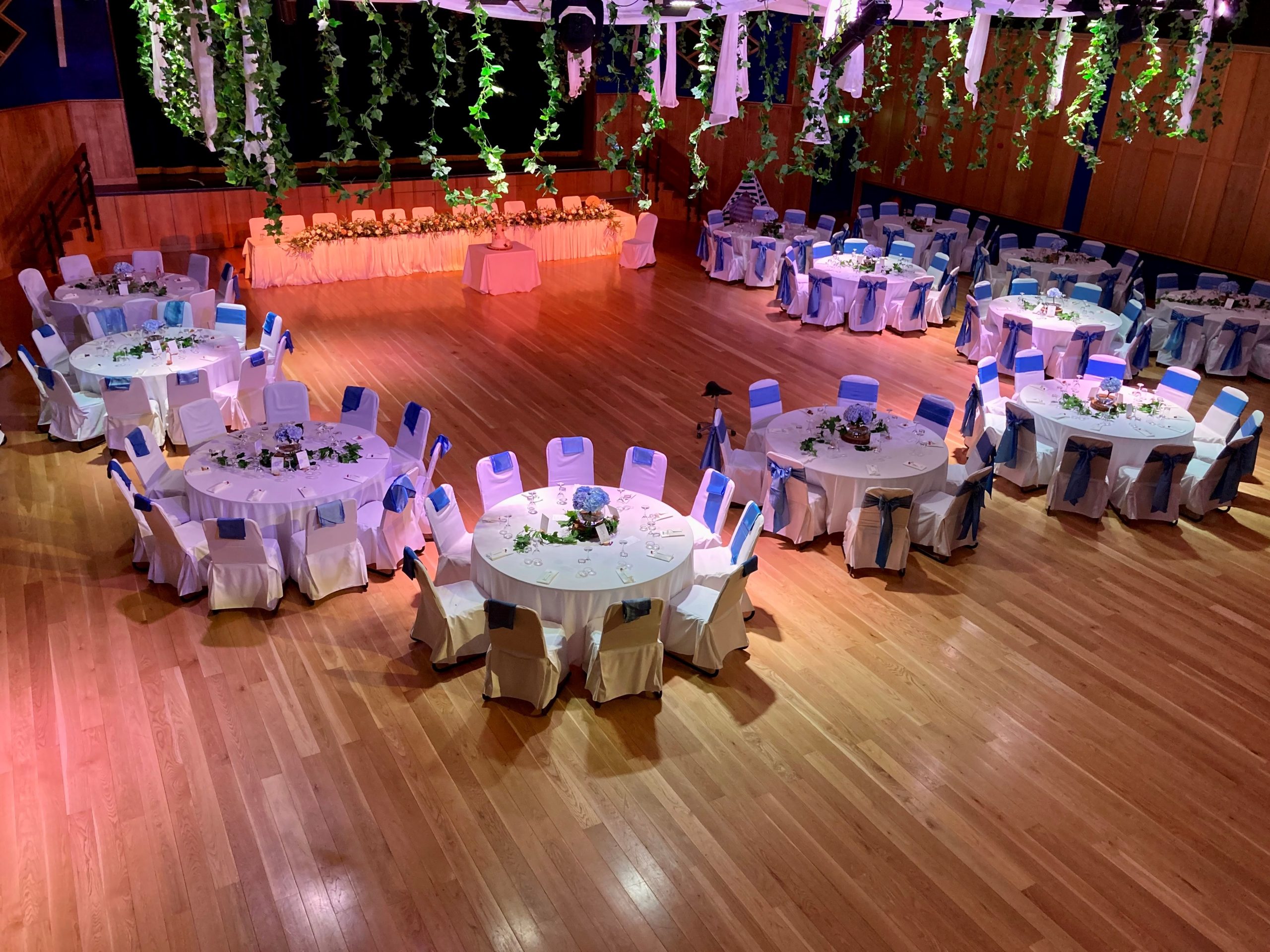 Image of large hall with round tables set up for wedding celebration