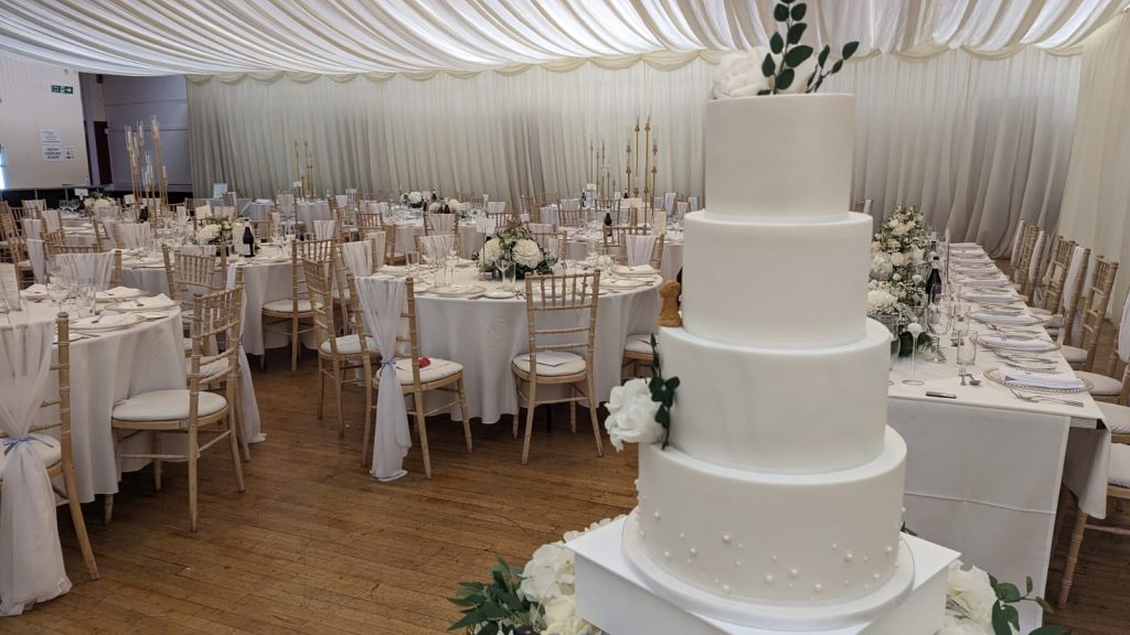 image showing tables set out for a wedding party and a large 4 tier wedding cake