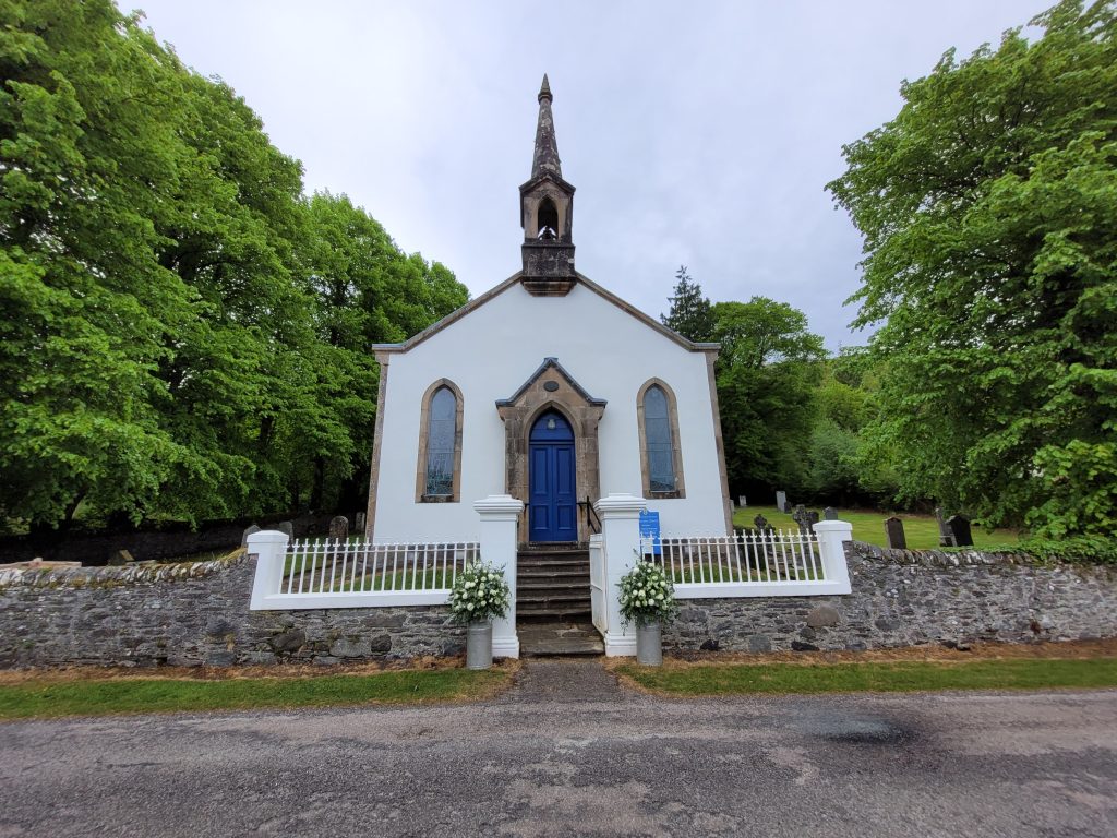 External image of a church style building surrounded by trees