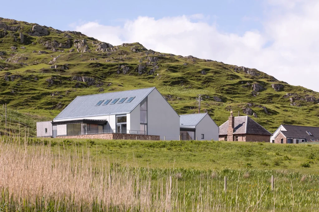 Image of a modern building set amongst green grass and hills