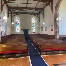 Internal of kilmun with rows of pews and blue carpet running up the middle
