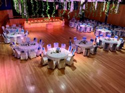Image of large hall with round tables set up for wedding celebration