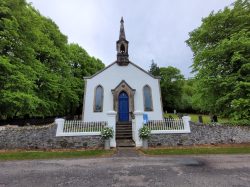External image of a church style building surrounded by trees
