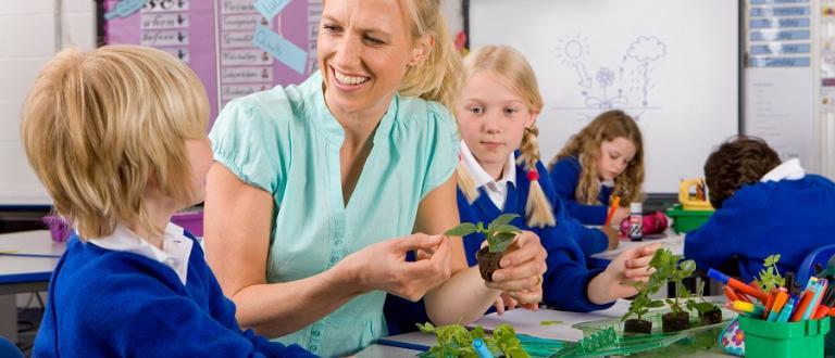 Teacher and pupils learning abut plants