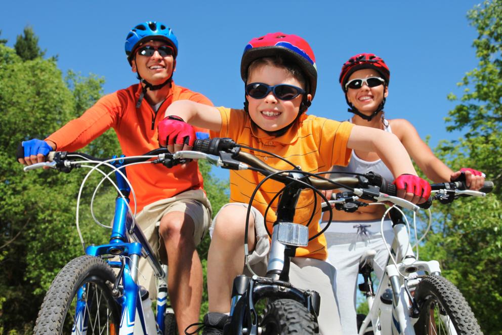 Images shows two adults and a young child on bikes 