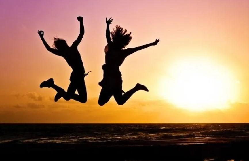 Image shows two young people jumping into the air celebrating 