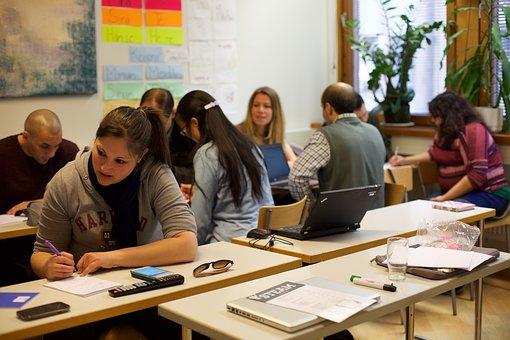 a group of adults working at desks in a learning environment