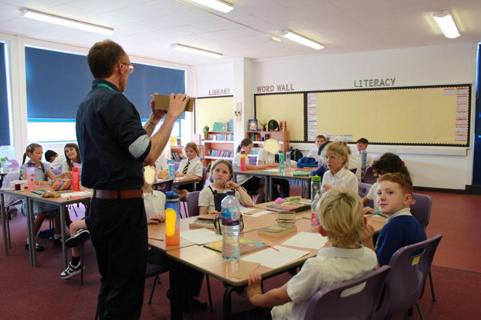 Image shows pupils  back in their classroom with their teacher 