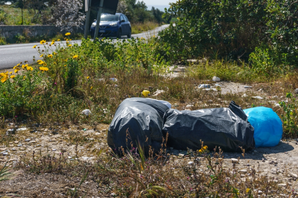 black plastic bags of rubbish lying at the side of the road
