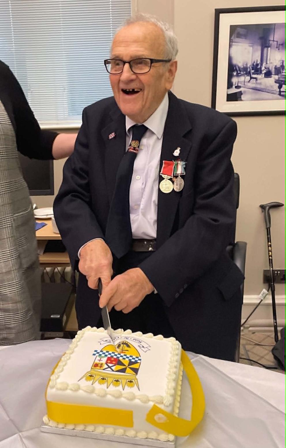Donnie MacMillan BEM cutting a cake