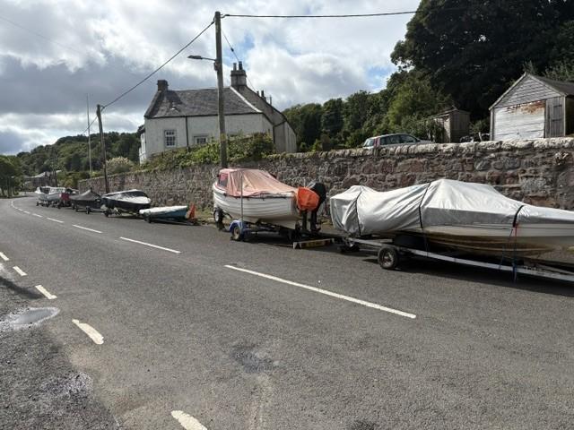 Image shows a line of boats and trailers 