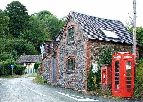 house with red phone box beside it