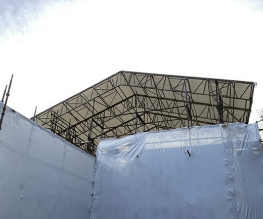 scaffold and temporary roof with shrink-wrap polythene sheeting protecting ongoing exterior works.