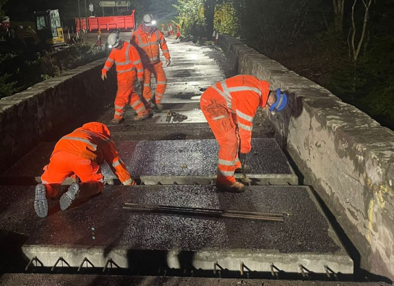 Workers lay two lay new slabs
