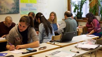 a group of adults working at desks in a learning environment