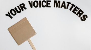 A placard with the words your voice matters above it.