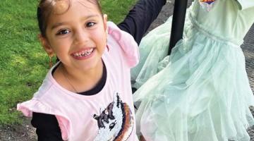 Image shows two girls, one on a rope swing smiling 
