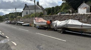 Image shows a line of boats and trailers 
