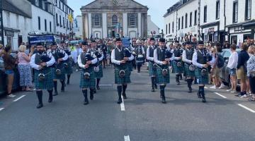 Image shows a pipeband marching down Inveraray's main road