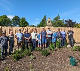 Lime and Mortar course attendees standing in front of covered wall they had been working on