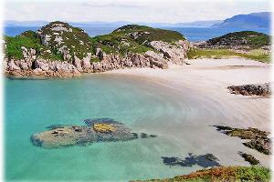 Images shows a bay on Colonsay with turquoise water and a sandy beach 