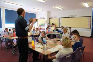 Image shows pupils  back in their classroom with their teacher 