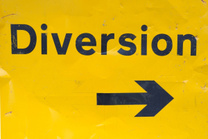 yellow sign with the word diversion in black and a black arrow pointing right