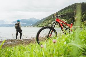 Image shows a bike in the foreground with a person looking out to the water in the background