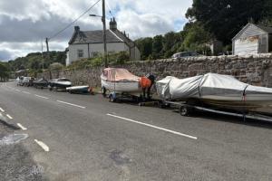 Image shows a line of boats and trailers 