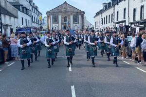 Image shows a pipeband marching down Inveraray's main road