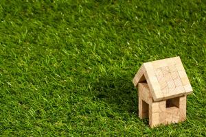 small wooden house on green grass backdrop