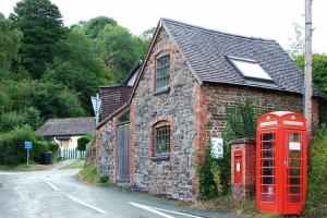 house with red phone box beside it