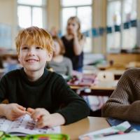 Young boy working at a desk in a school classroom