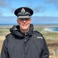 A photo of Gary I'Anson on Tiree with the sky, machair and sand behind him