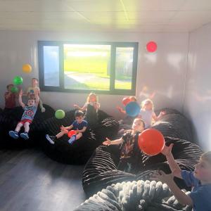 Children pictured in their new learning space with brightly coloured balloons