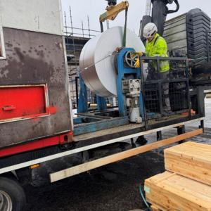 Image shows a site worker producing the roofing sheets 